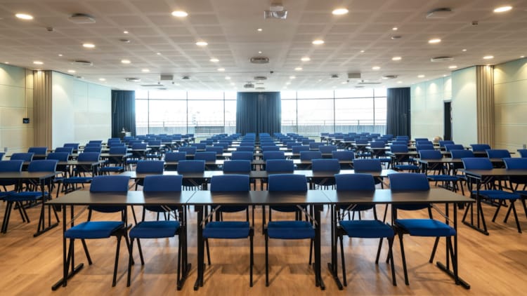 Stor konferansesal i klasseromsoppsett med projektor