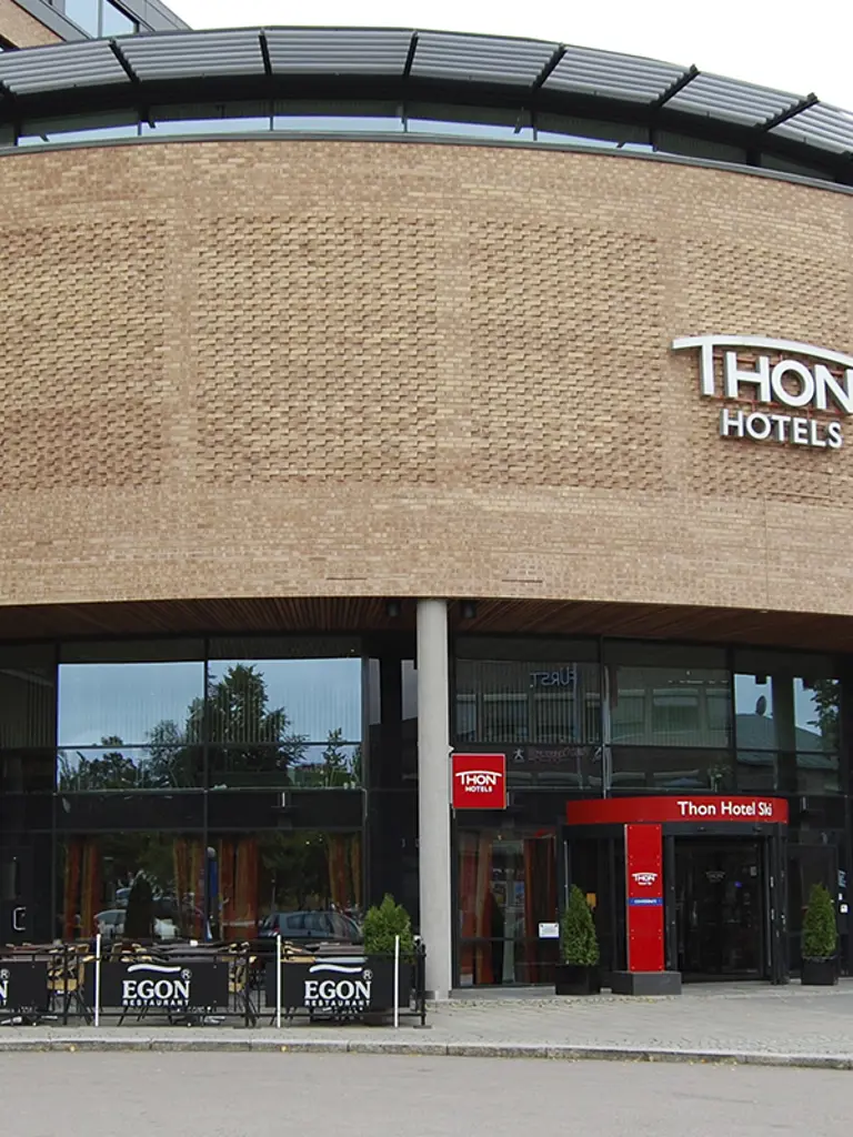 Forsiden av en stor mursteinbygning med et skilt som sier "Thon".