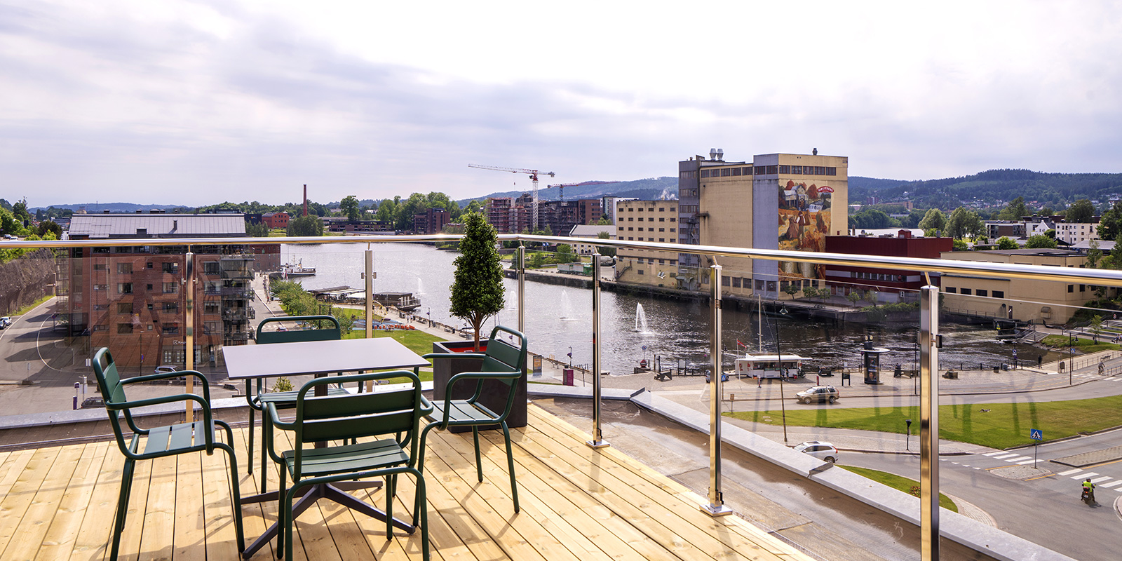 Stor veranda med bord og stoler og utsikt over byen