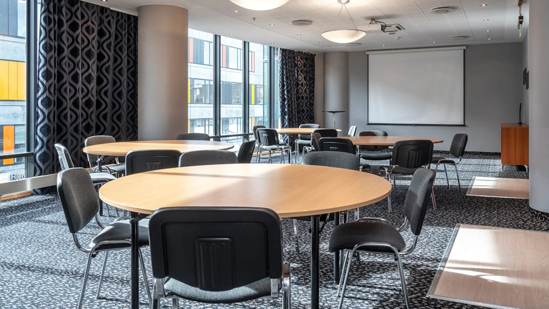 Møterom med flere runde møtebord og tilhørende stoler på Stavanger Forum Hotel