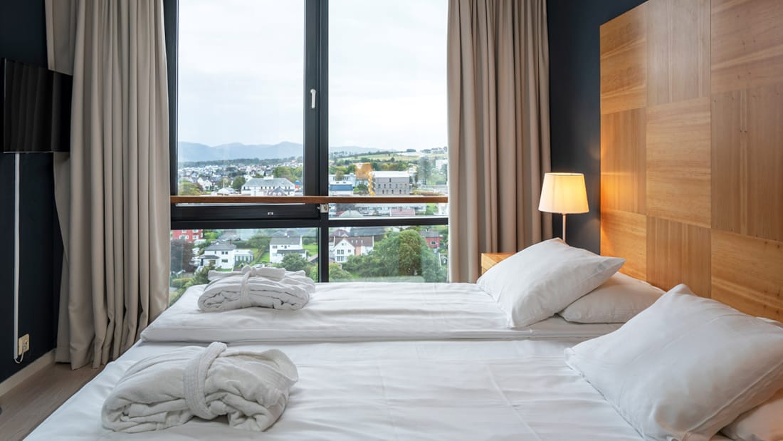 Dobbeltseng foran vindu med utsikt på suite på Stavanger Forum Hotel