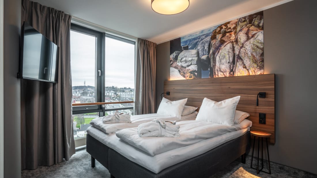 Dobbeltseng foran vindu med utsikt på suite på Stavanger Forum Hotel