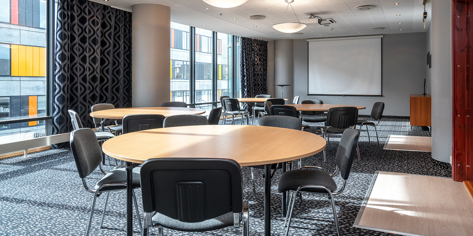 Møterom med flere runde møtebord og tilhørende stoler på Stavanger Forum Hotel