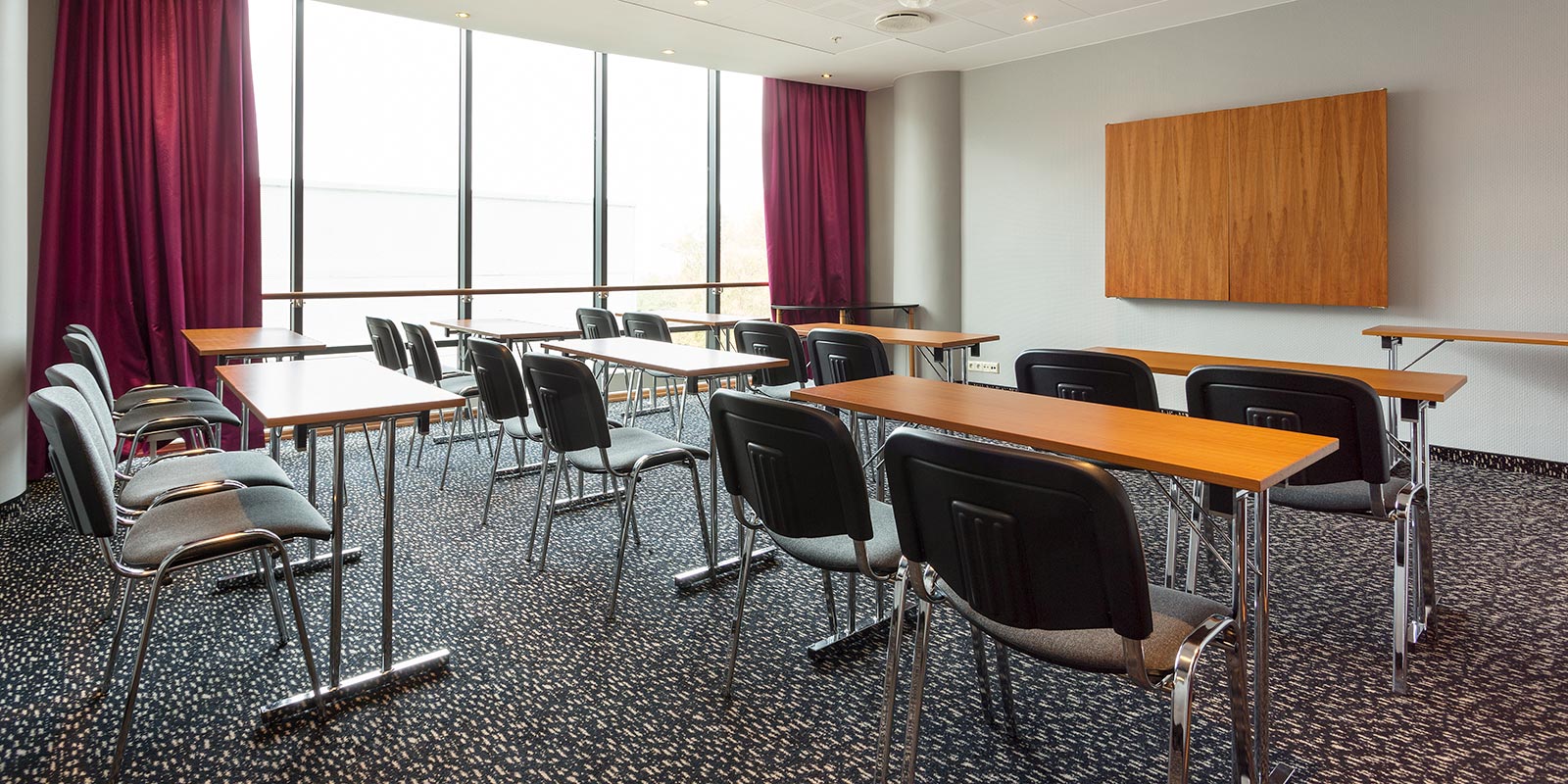 Møterom i klasseromsoppsett med store vinduer