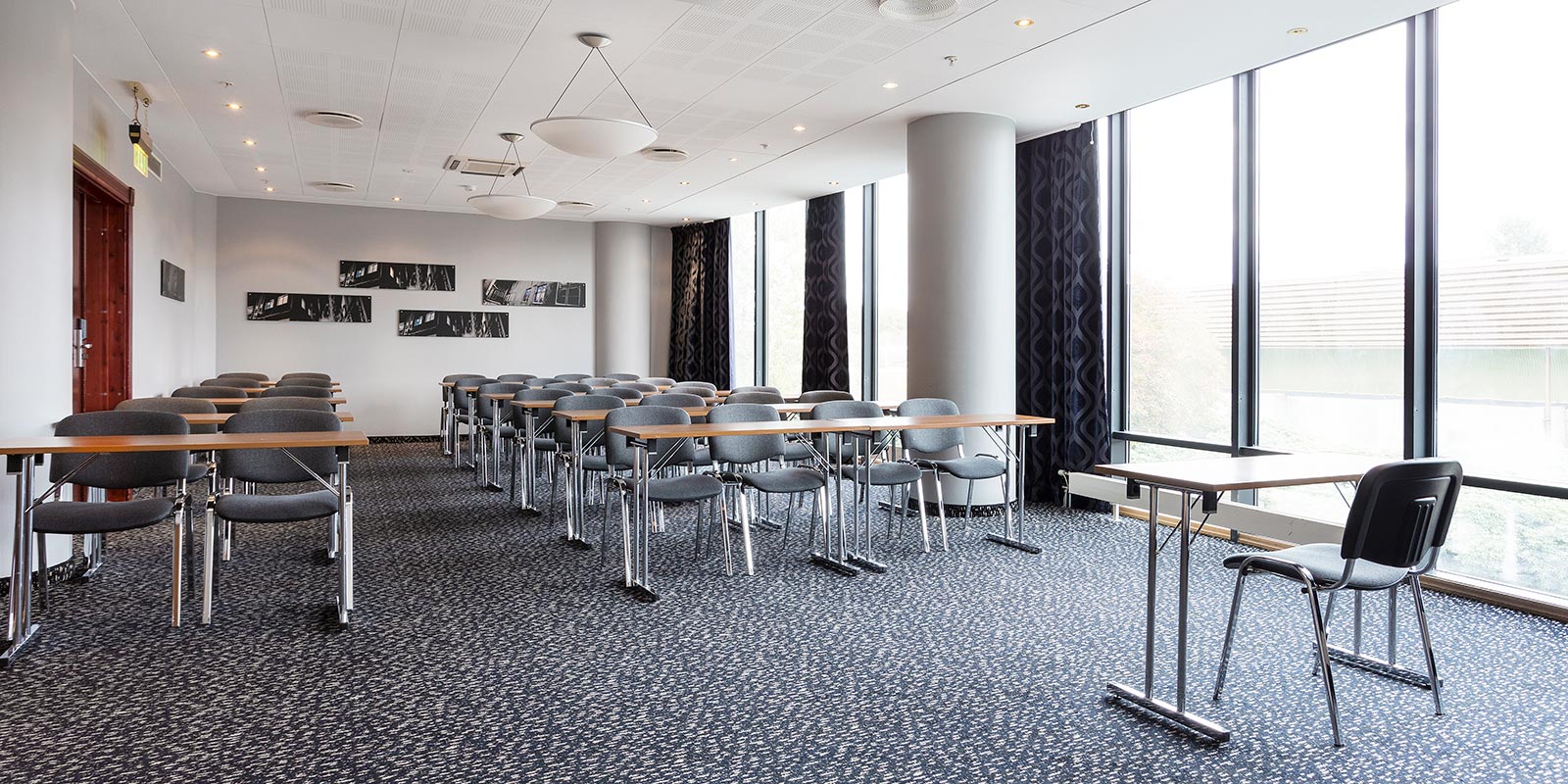 Møterom i klasseromsoppsett med store vinduer