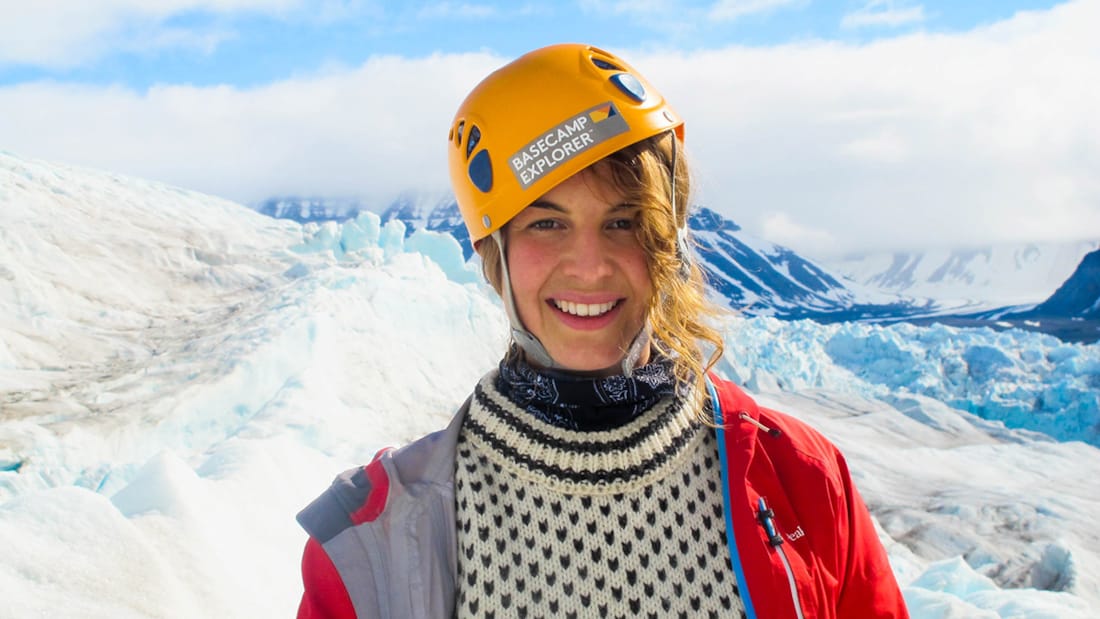 Kvinne med hjelm i vinterlandskap på Svalbard