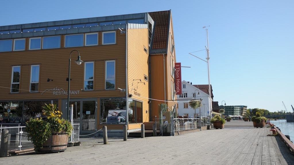 Fasaden til Thon Hotel Tønsberg Brygge med gule vegger og plassering på Brygga i Tønsberg sentrum.