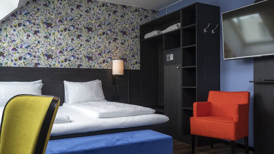 Seng og lenestol i superior room på Thon Hotel Tromsø