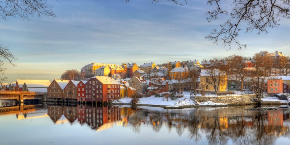 Trondheim på vinterstid som speiler seg i vannet