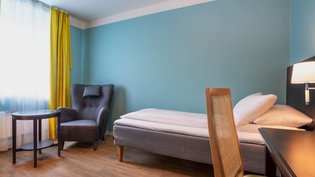 Seng og sitteplass i Standard Room Single på Thon Hotel Linne Apartments