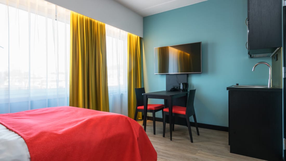 Dobbeltseng, smart-TV og kjøkkenbord på 1 roms leilighet på Thon Hotel Linne Apartments