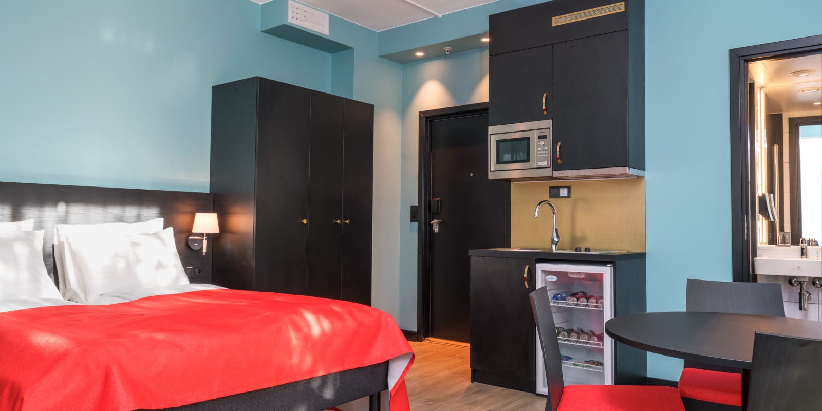 Dobbeltseng, skap, minikjøkken og kjøkkenbord på 2 roms leilighet på Thon Hotel Linne Apartments 