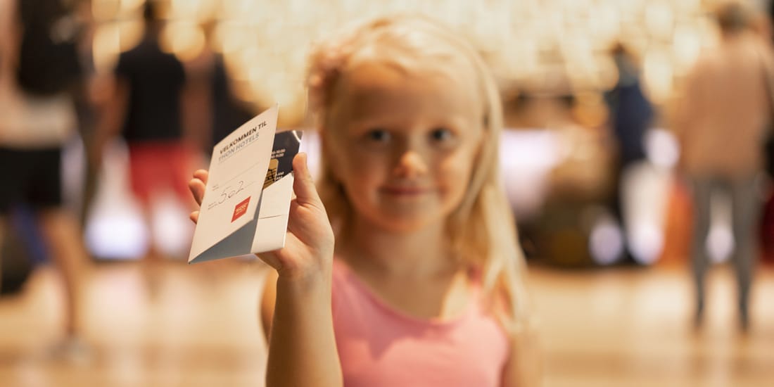 Liten jente viser stolt frem nøkkelkort på Thon Hotel Opera