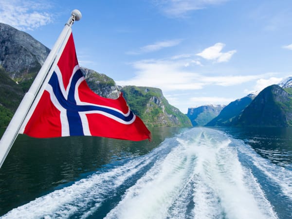 Bilde av Norges flagg på en båt ute på havet.