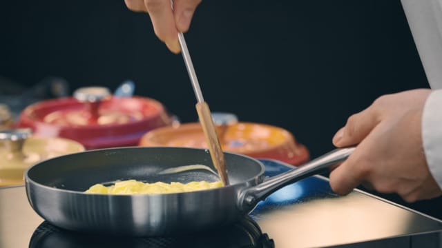 En kokk som steker omelett i stekepanne