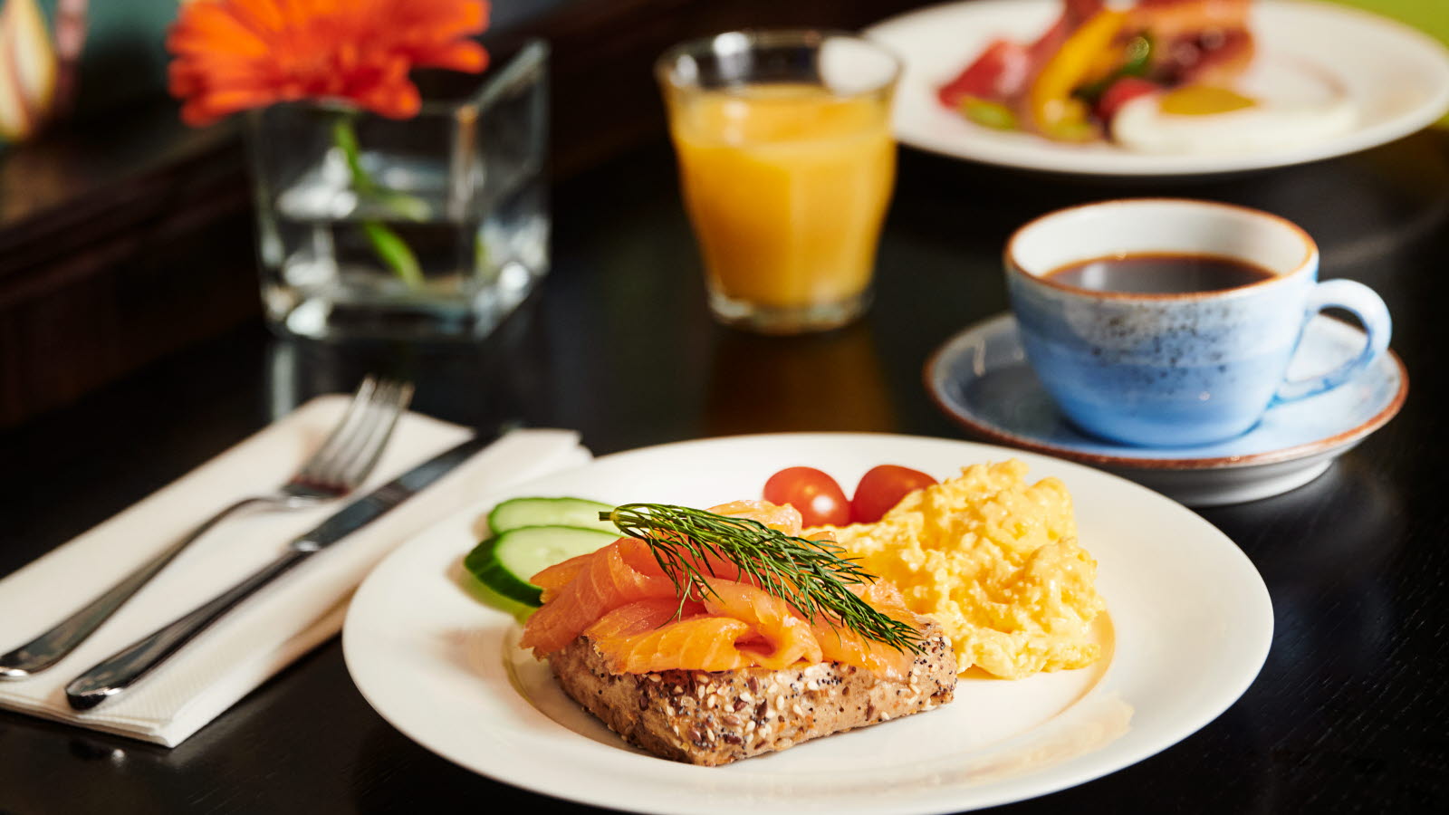 Bord med en tallerken med frokost, kaffe og juice