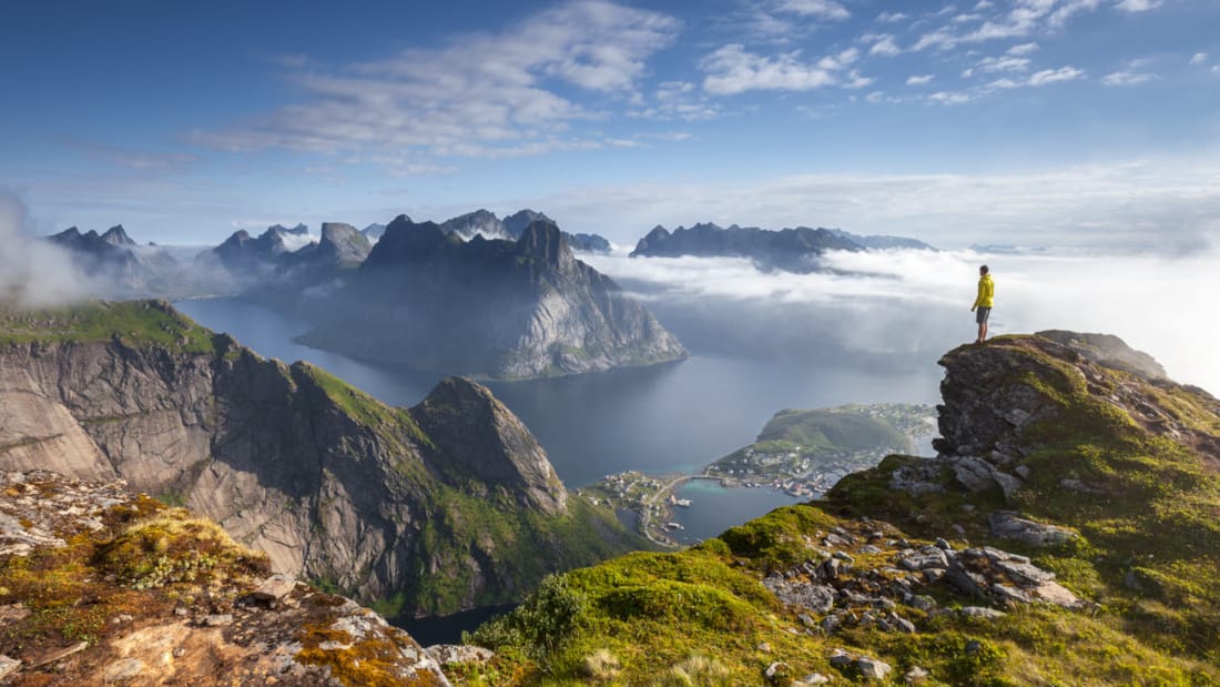 Person som står på toppen av et fjell og ser utover Lofoten