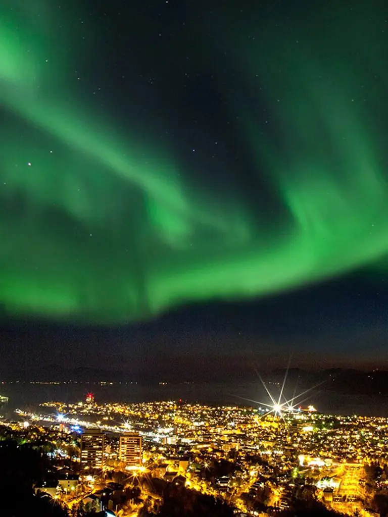 Foto: Michael Ulriksen Nordlys over Narvik by som lyser opp i nattemørket.