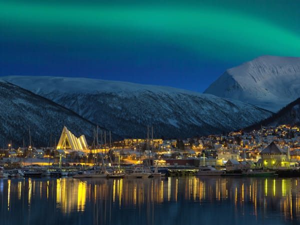 Nordlys som kaster lys over Tromsø by