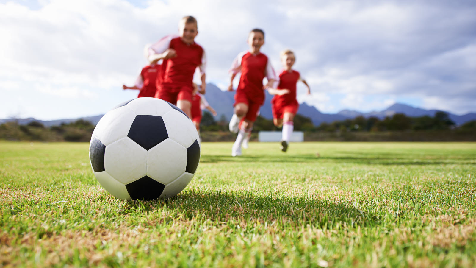 Fotballspillere i aksjon på en gressbane på Norway Cup