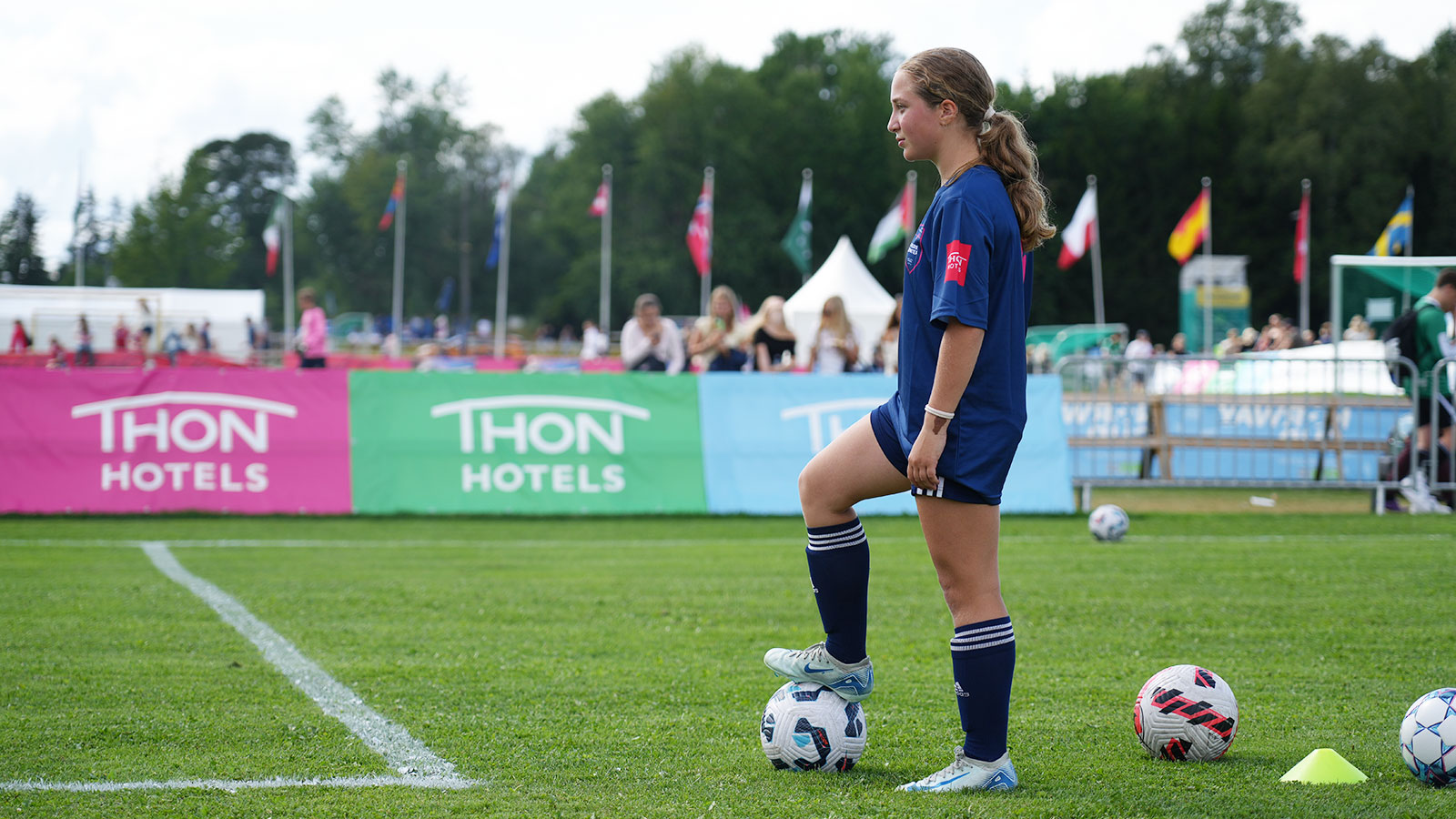 Fotballspiller i aksjon på en gressbane på Norway Cup