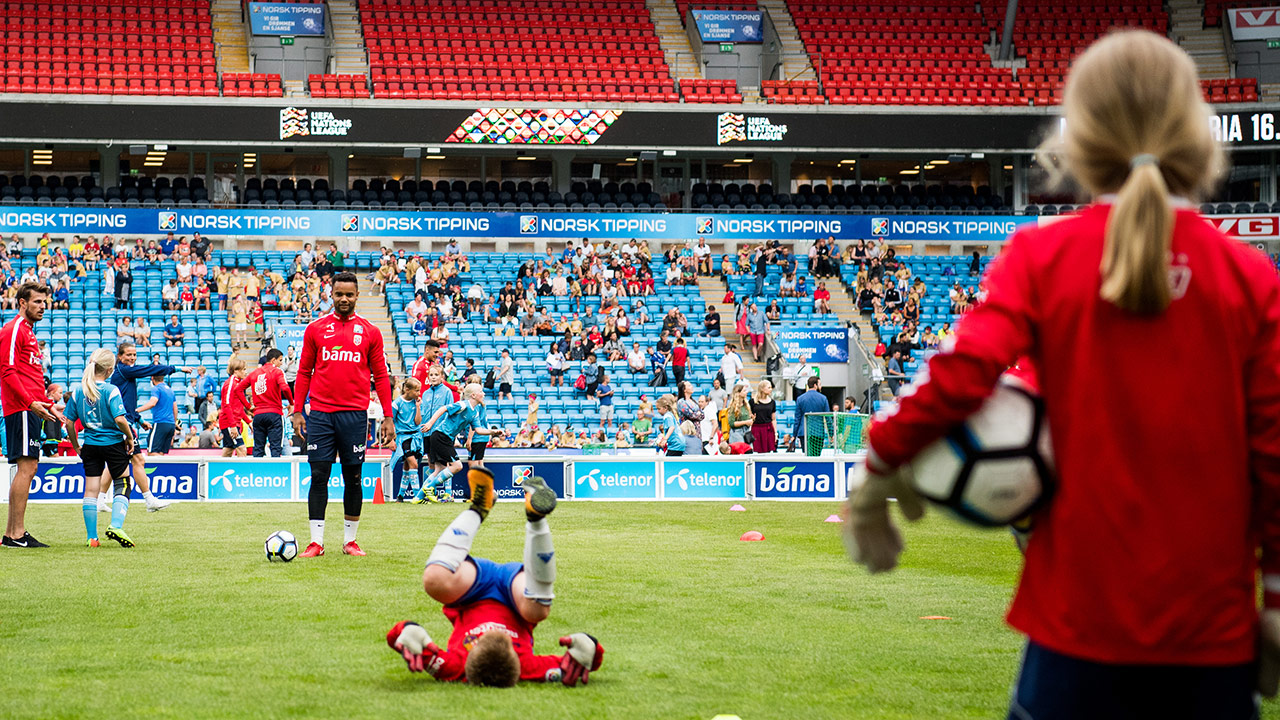 Barn som trener fotball på en fotballstadio