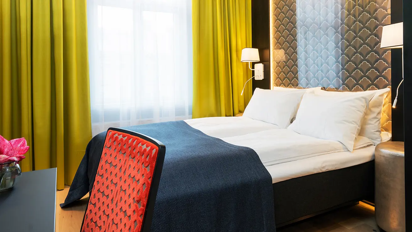 Seng og skrivebord på hotellrom på Thon Hotel Spectrum i Oslo