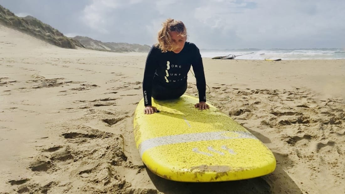 Kvinne som ligger på surfebrett