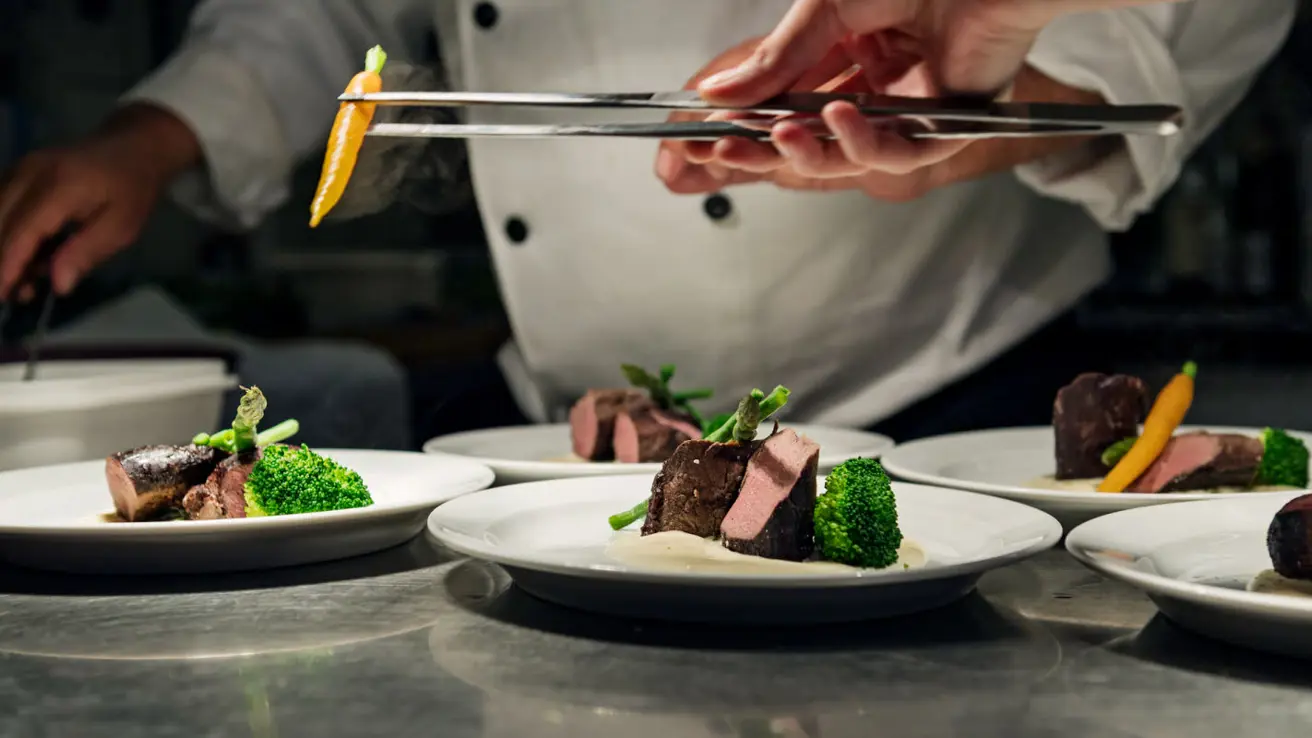 Kokk legger opp mat klart til servering