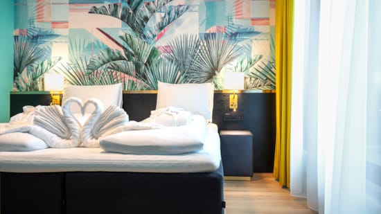 Redd seng med svaneformede håndklær på sengen på Thon Hotel Storo