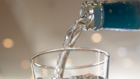 Vann som helles fra flaske til glass