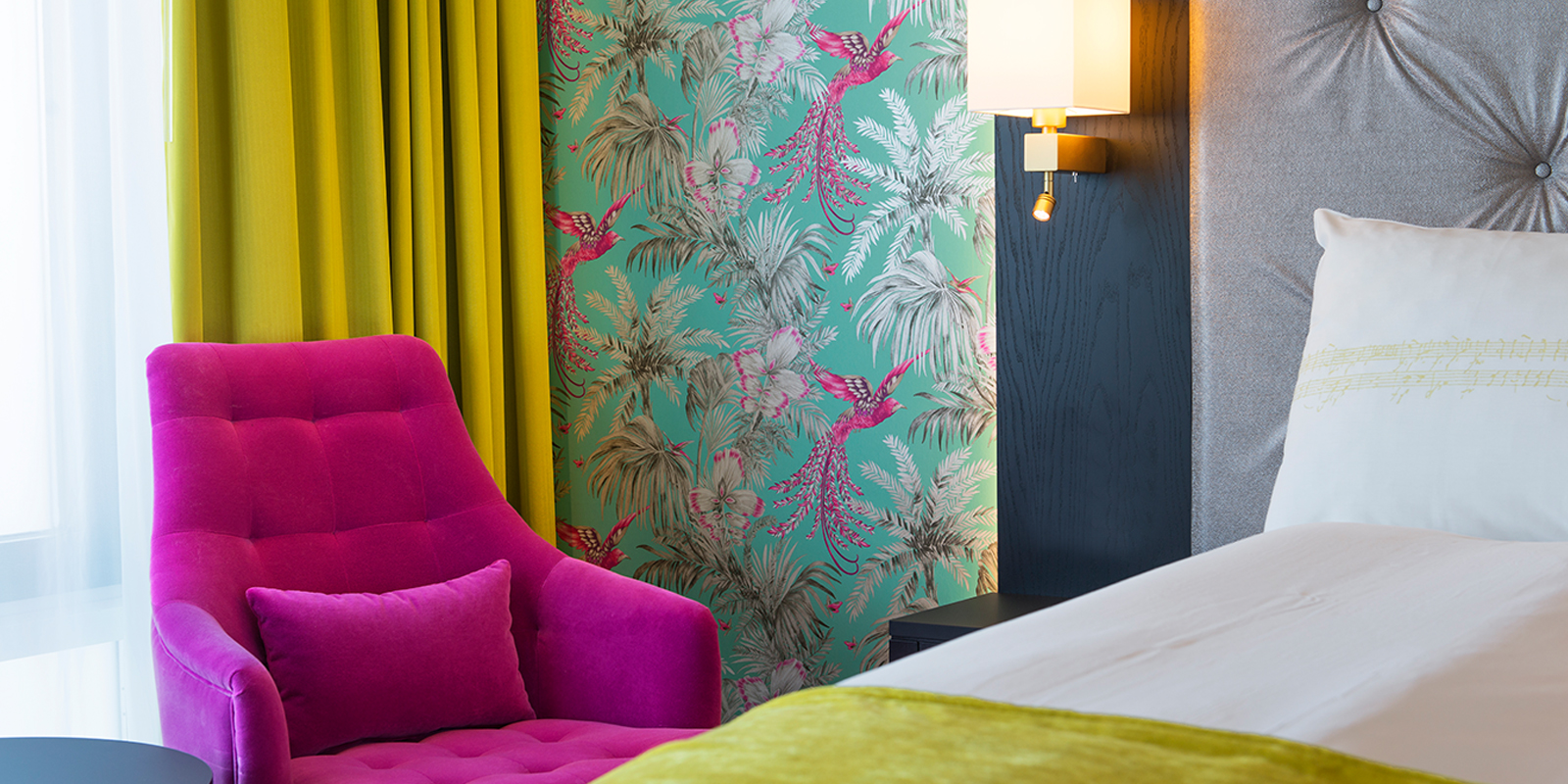 Rosa stol ved siden av hotellseng