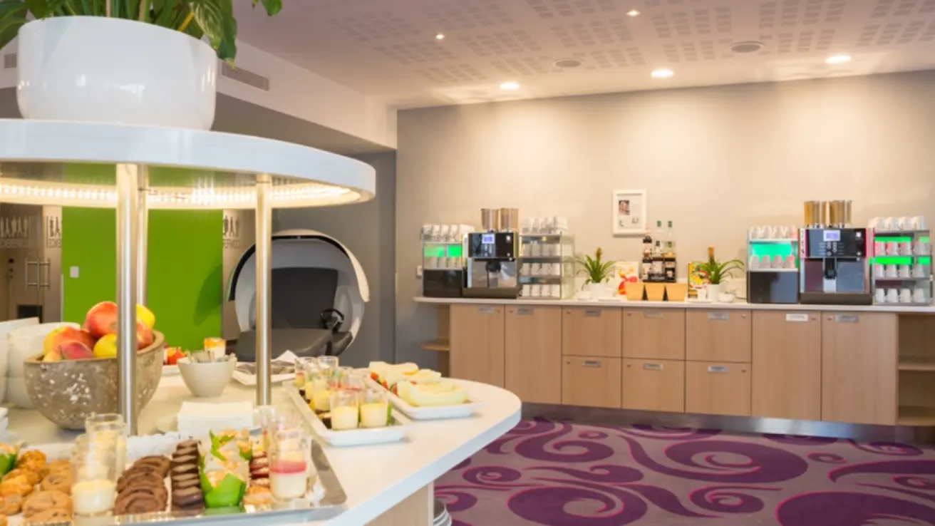 Fargerikt pauseområde med kaffe, frukt og bakevarer.