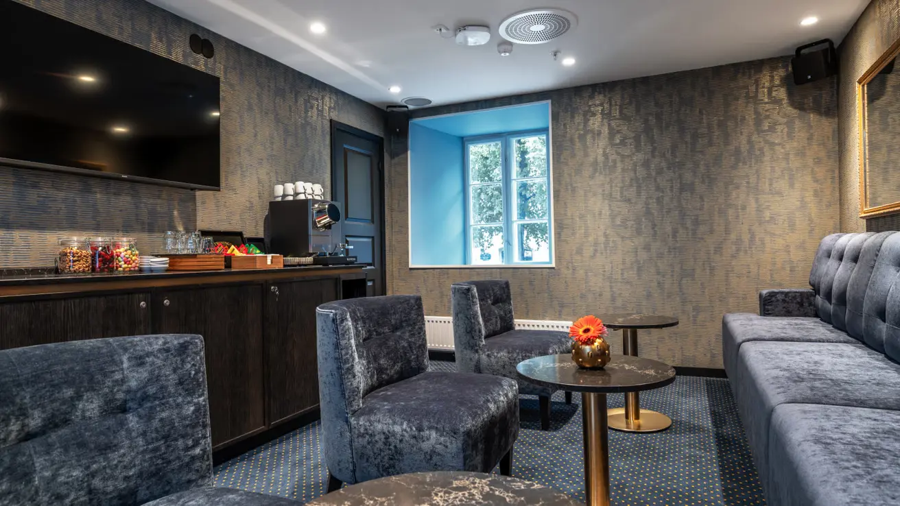 Loungeområde med myke lenestoler og sofaer, et kjøkken med mat og drikke.