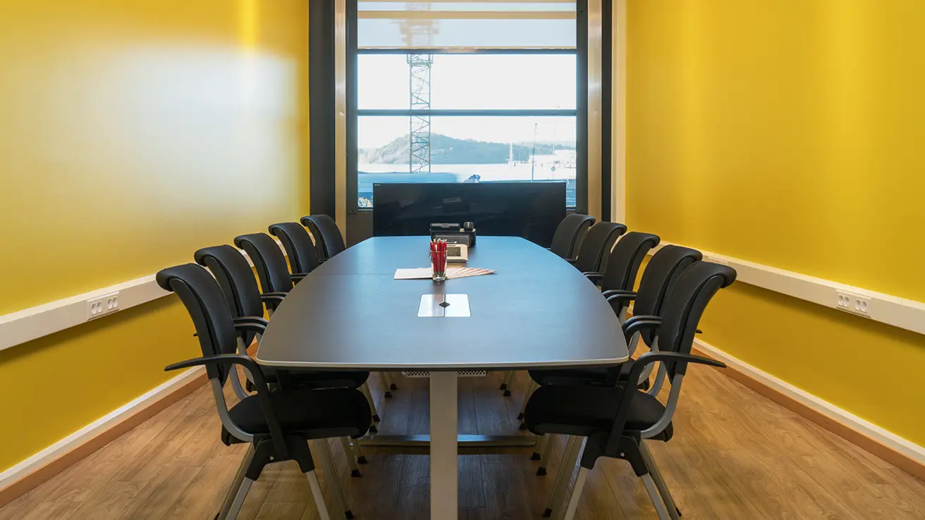 Møterom med langbord og et stort vindu